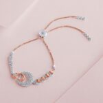 Close-up of a delicate rose gold and silver bracelet on a soft pastel background, showcasing intricate jewelry design.